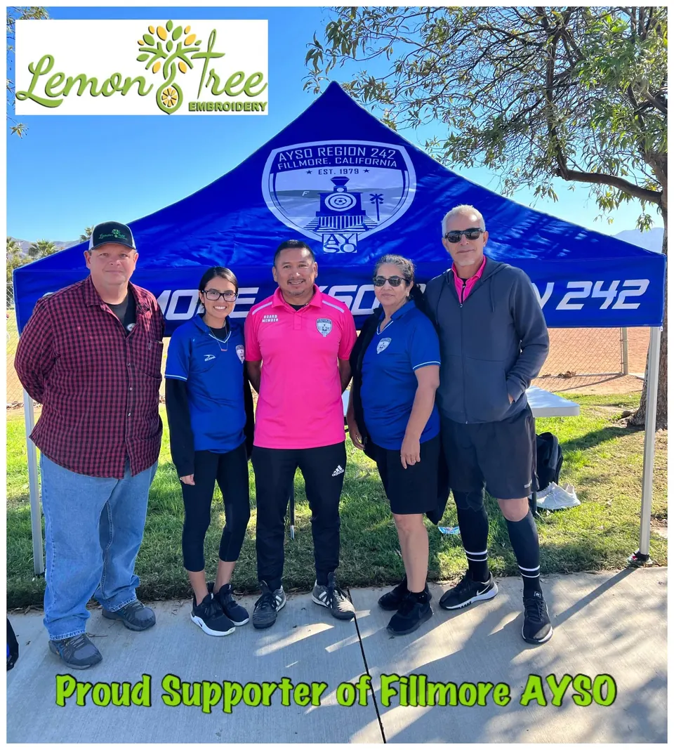 Five people in front of a blue AYSO Region 242 display tent at a soccer field