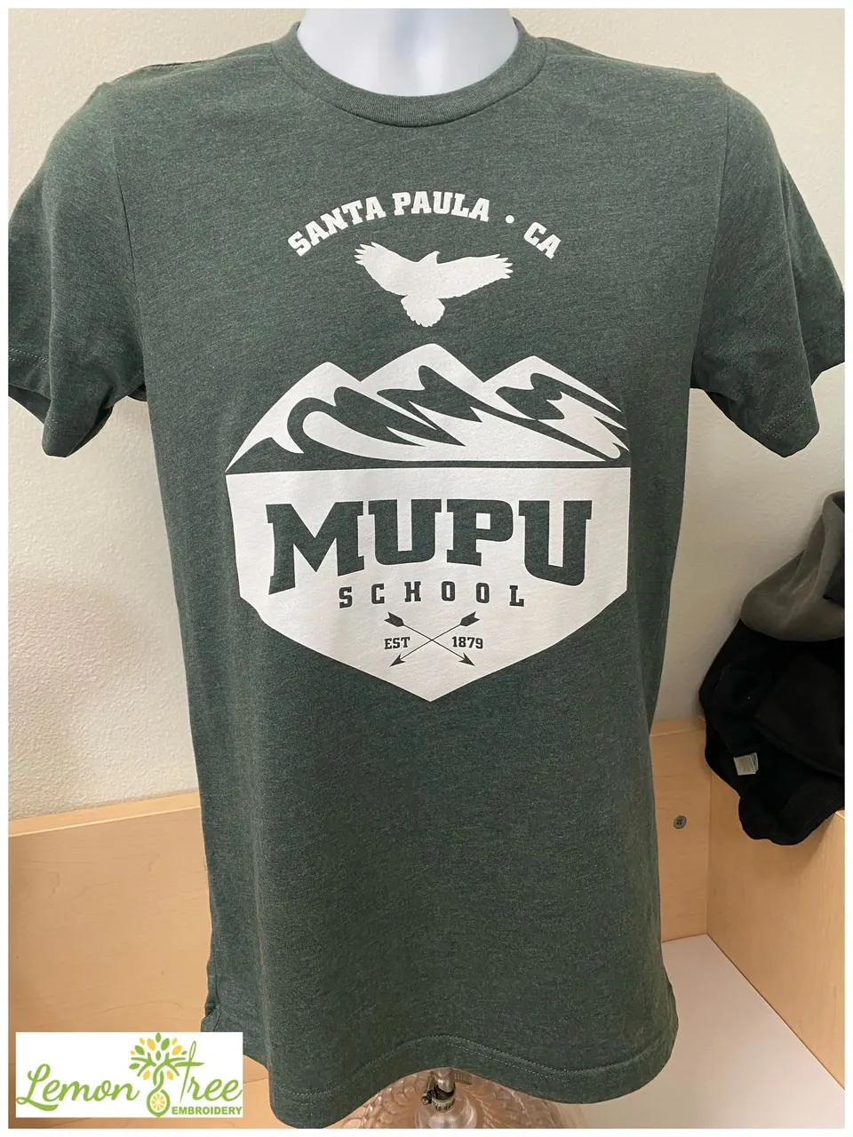 Green tee printed with the MUPU School Santa Paula logo in white